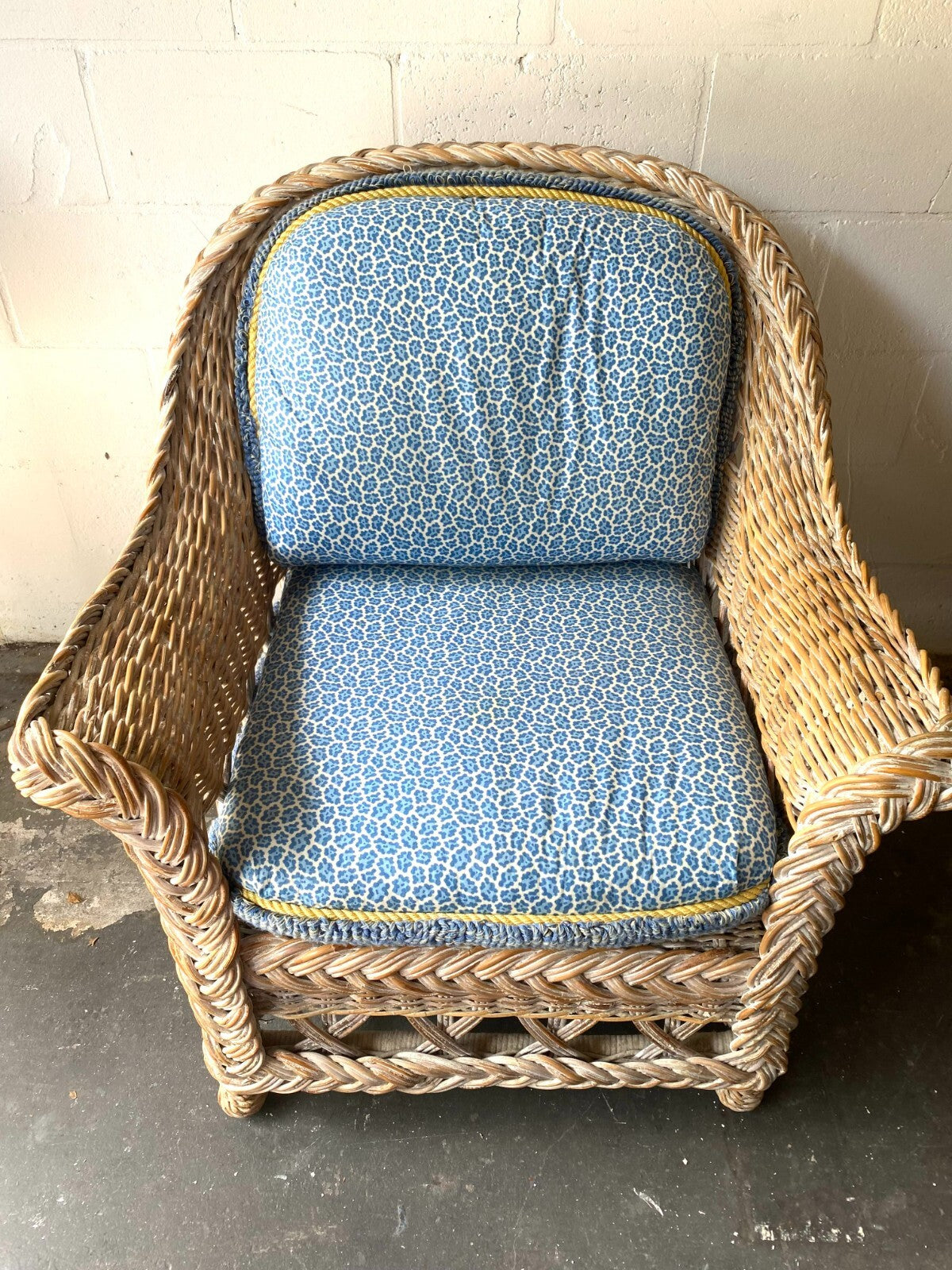 Beige Wicker Chair With Arm Rest Blue Cushion And Square Matching Ottoman